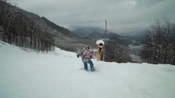 Повільний рух впритул взяти до чоловічої сноубордист, який їхав на порожній і величезні гірськолижної траси. — стокове відео