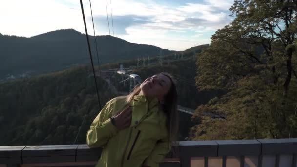 Menina bonito olhando para a câmera amigável na frente das árvores de outono. Menina desfrutar de outono brilho quente enquanto caminha fora. Caminhando no Skypark . — Vídeo de Stock