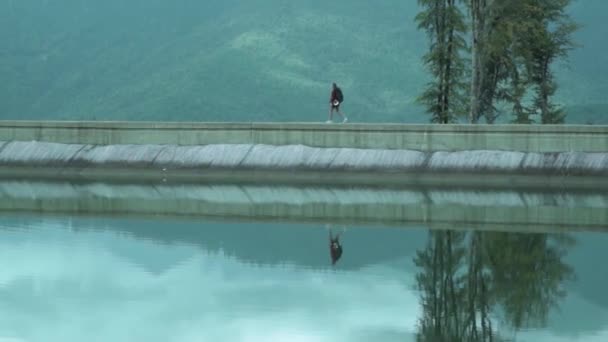 Kleine figuur van wandelaar dame die zelf bergen en meren, terwijl advanturies en vakantie onderzocht — Stockvideo