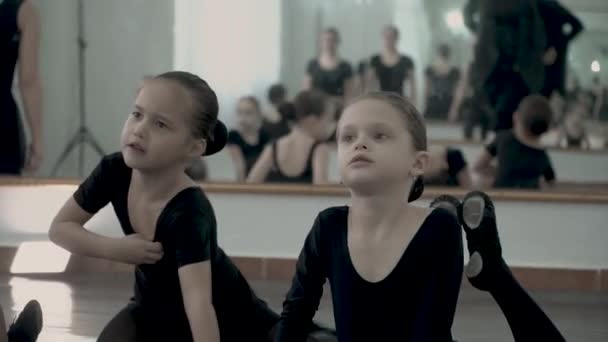 Kleine ballerina's gekleed in zwarte pakken zijn opwarmen en lachen tijdens baby danslessen — Stockvideo