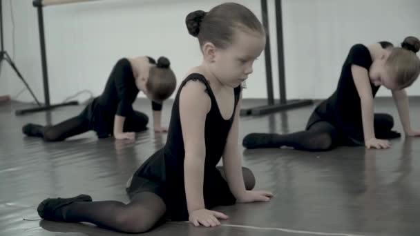 Primer plano pequeño bailarín de ballet tratando de copiar el movimiento y el calentamiento en la clase de baile . — Vídeos de Stock