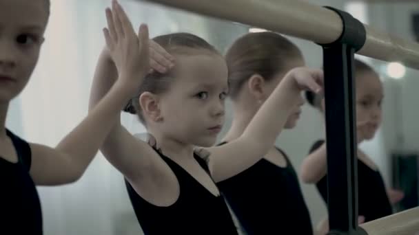 Kleine europäische Balletttänzerin versucht ihre Arme geschmeidig und sanft zu bewegen. Junge Balletttänzerin konzentriert sich auf das Erlernen geschmeidiger Bewegungen. — Stockvideo