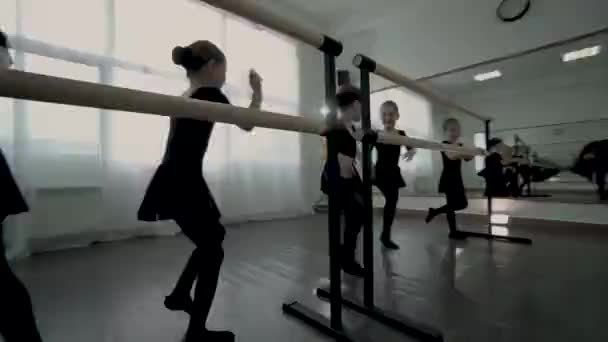 Pequenas bailarinas vestidas de couro preto ballet barre Crianças se divertir na aula de dança . — Vídeo de Stock