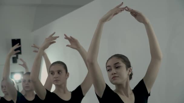 Lento movimiento de las bailarinas jóvenes que mantienen esas manos por encima de la cabeza que la posición de ballet . — Vídeos de Stock