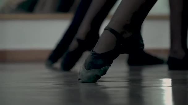 ダンスクラスの最初のステップ。黒い尖った靴にクローズアップ。子供の足はバッテメントテンドゥを作る.バレリーナ・ド・バッテメント・テンドゥ — ストック動画