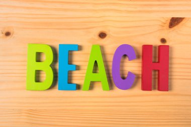 Ahşap ahşap renkli harflerle kelime kumsalda