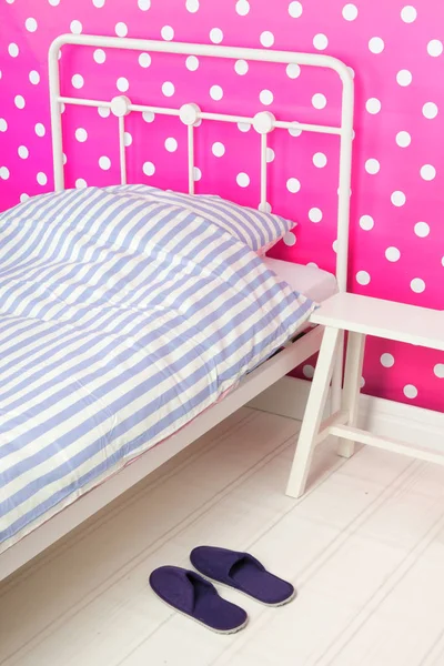 Pink bedroom with bedstead and slippers