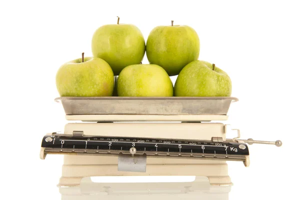 白い背景に隔離された体重計に緑のリンゴ — ストック写真