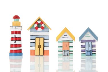 Minyatür sahil kulübeleri ve beyaz arka planda izole edilmiş aydınlık evler.