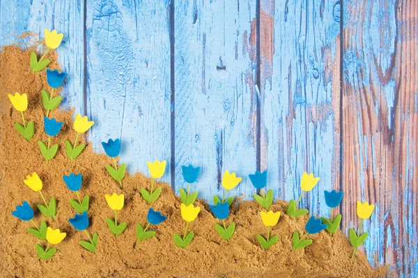 Blauer Vintage-Hintergrund mit Blumen im Sand — Stockfoto