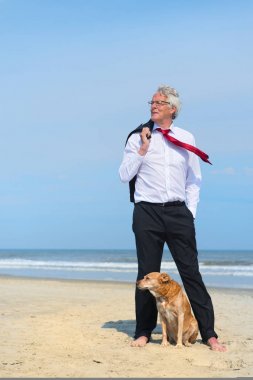 Business man with dog at the beach clipart