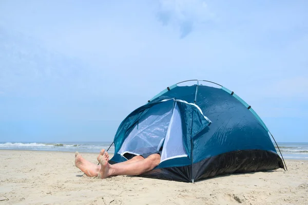 Homem acampando em abrigo na praia — Fotografia de Stock