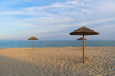 Korsika adasında hasır şemsiyeli manzara