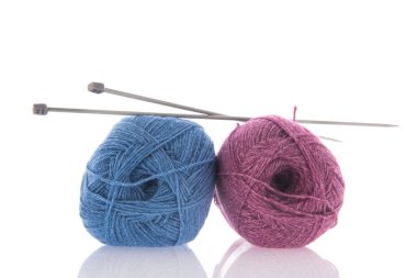 Beyaz arka planda izole edilmiş iğneli mavi ve pembe yün örgü.