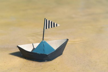 Mavi kağıt tekne suda yüzüyor.