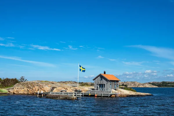 Casa de campo e bandeira na ilha Valoen perto da cidade Fjaellbacka — Fotografia de Stock