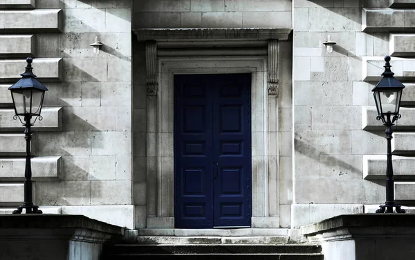 Μπλε ζωγραφισμένα ξύλινη πόρτα με συμμετρικούς αναπτήρες στις πλευρές — Φωτογραφία Αρχείου