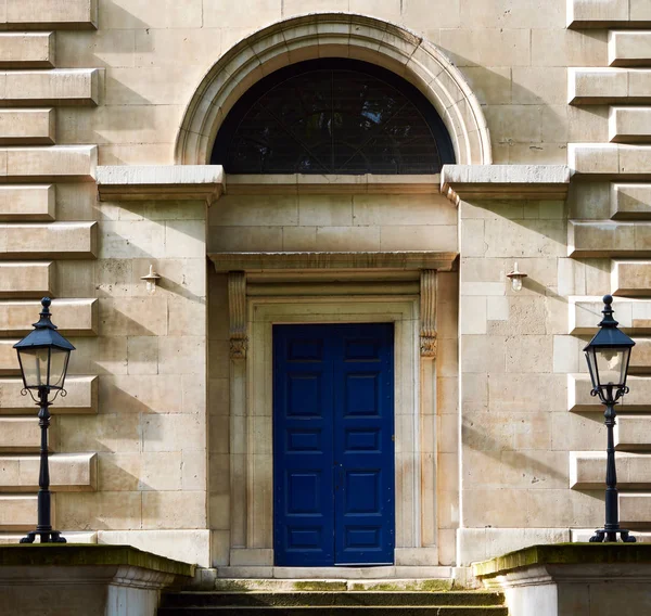 Yanlarında simetrik çakmaklar ile mavi boyalı ahşap Kapı — Stok fotoğraf