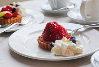 lezzetli zanaat shortbread meyve kek ve beyaz plaka, seçici odak üzerinde krem şanti ile çay saati