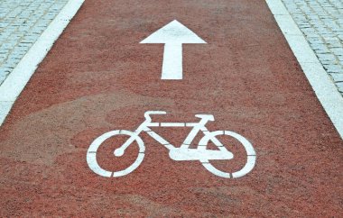 Beyaz ok ve mozaik bir bisiklet yolu kırmızı taş yüzeyinde döngüsü