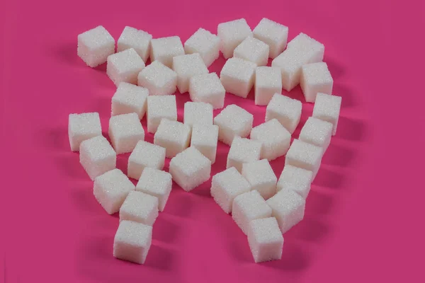 Sugar destroys the tooth enamel and leads to tooth decay. Sugar cubes are laid out in the form of a tooth and cavity — Stock Photo, Image