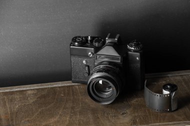 Kartuş klasik bir arka plan üzerinde eski retro kamera ve 35 mm film.