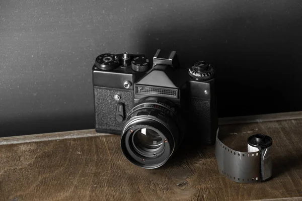 Kartuş klasik bir arka plan üzerinde eski retro kamera ve 35 mm film.