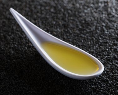 Siyah susam ağacının arka planında küçük bir kasede susam yağı. İlaç ve yemek pişirmede kullanılır..