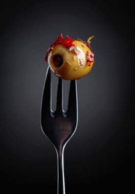 Baharatlı yeşil zeytin yağı çatal üzerinde.