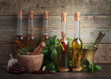 Zeytin yağı ile farklı baharatlar ve otlar üzerinde eski bir ahşap masa.