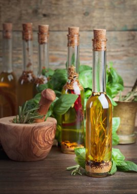 Zeytin yağı ile farklı baharatlar ve otlar üzerinde eski bir ahşap masa.