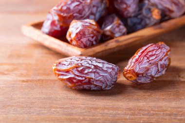 Eski ahşap bir masada sulu olgun tarihler.