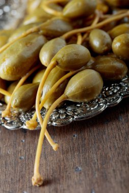 Metal tabak içinde turşu Kapari Karpuzu. Çilek garnitür olarak kullanılır. Eski ahşap arka plan.