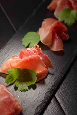 Prosciutto maydanoz siyah bir tablo ile. Sağlıklı organik gıda . 