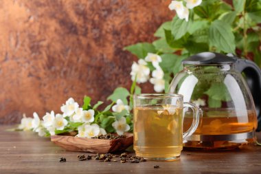 Yasemin Kupası ve çaydanlık eski ahşap masa üzerinde yeşil çay. Kopya alanı.
