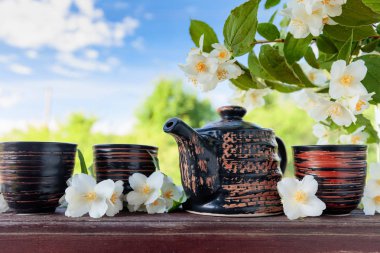 Jasmine tea in small ceramic cups on old wooden table in garden . Copy space. clipart