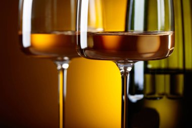 Gözlük ve sarı bir arka plan üzerinde beyaz şarap. Seçici odak .