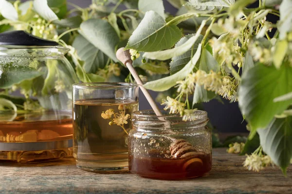 木製のテーブルの上に花と蜂蜜のリンデン茶のガラス — ストック写真
