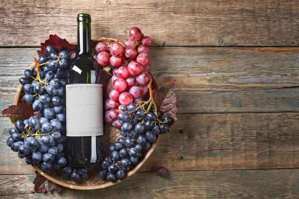 ブドウと木製のテーブル上のバスケットの赤ワイン 古い紙ラベル テキストのコピー スペース トップ ビュー — ストック写真
