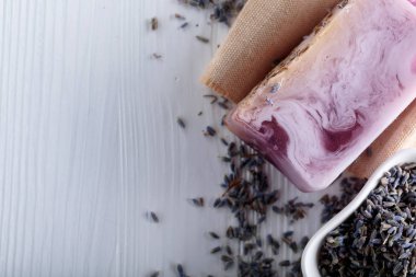 Eflatun Beyaz ahşap zemin üzerinde doğal organik sabun Bar. El yapımı Sabun yapımı. Spa Ürünleri ve cilt bakım kavramı. Kopya alanı.