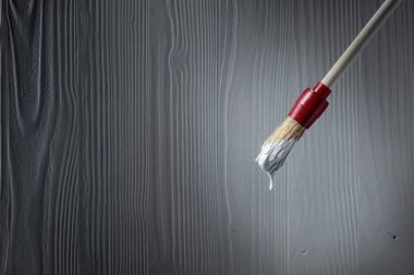 Eski ahşap duvar bir arka plan üzerinde beyaz boya ile boya fırçası. Kopya alanı.