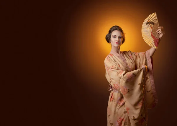 年轻漂亮的女人在传统的日本和服与粉丝跳舞 完美的发型和妆容 为您的内容腾出空间 — 图库照片