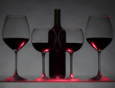 Gözlük ve karanlık bir arka plan üzerinde kırmızı şarap şişe.