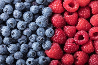  Olgun ve sulu taze meyveleri tatlı aldım. Yaban mersini ve ahududu arka plan.