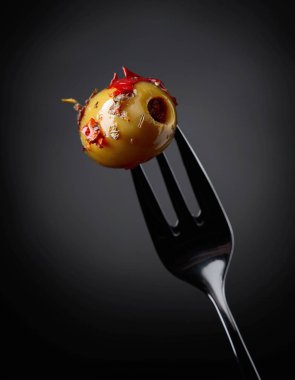 Baharatlı yeşil zeytin yağı çatal üzerinde.