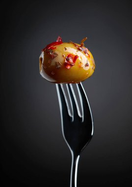 Baharatlı yeşil zeytin yağı çatal üzerinde.