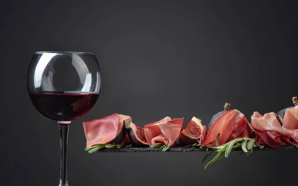 Prosciutto Mit Feigen Rosmarin Und Einem Glas Rotwein Auf Schwarzem — Stockfoto