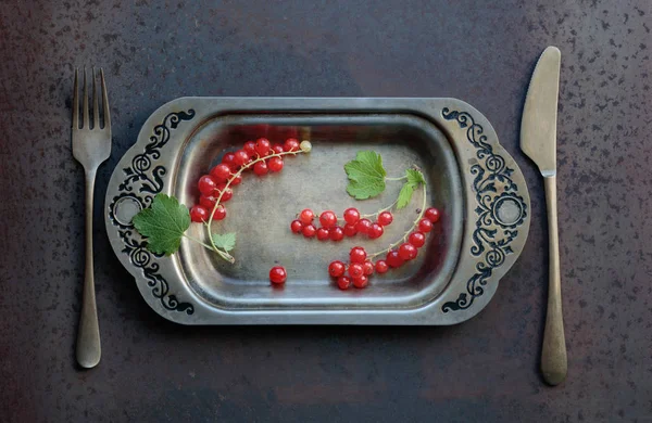 Redcurrants metal çanak çatal ve bıçak üzerinde. Sağlıklı beslenme, diyet ve antioksidan için kavram. Üstten görünüm.