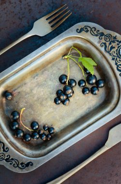 Blackcurrants metal çanak çatal ve bıçak üzerinde. Sağlıklı beslenme, diyet ve antioksidan için kavram.