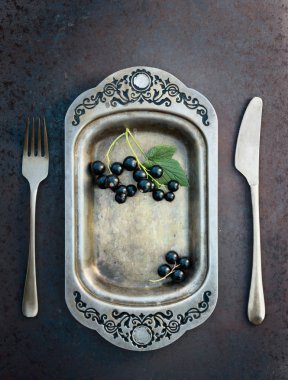 Blackcurrants metal çanak çatal ve bıçak üzerinde. Sağlıklı beslenme, diyet ve antioksidan için kavram.